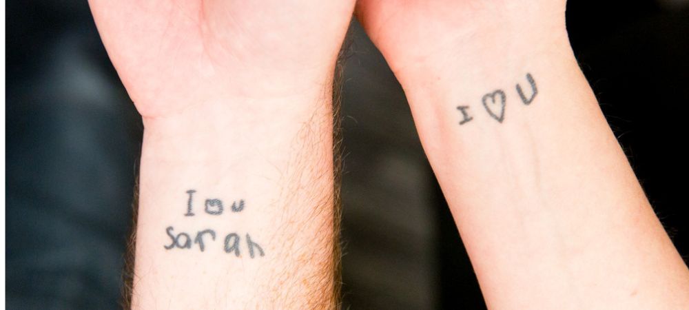 WRISTS TATTOOED WITH THE NAMES OF LOVED ONES