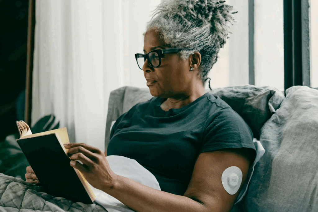 woman with type one diabetes reading book in a chair