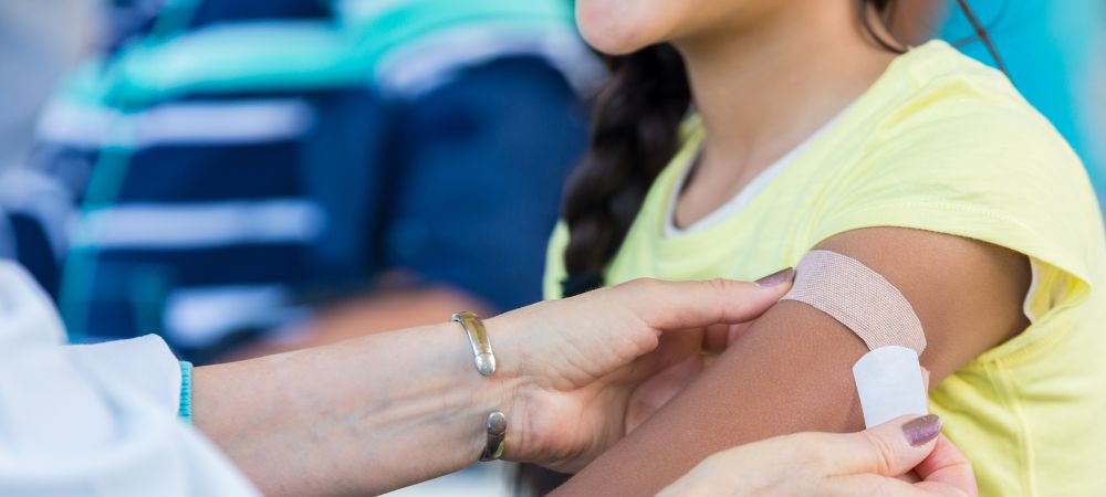 nurse applying bandaid to child